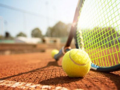 A low angle view of a tennis court, tennis racquet and ball