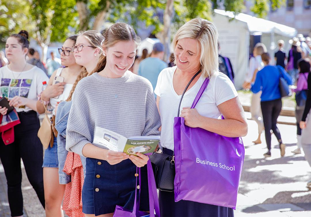 Mother and daughter reading a brochure at UQ Open Day.